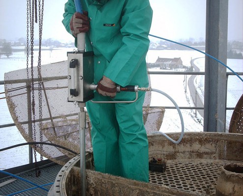 Worker in Greensuit using Peinemann Equipment